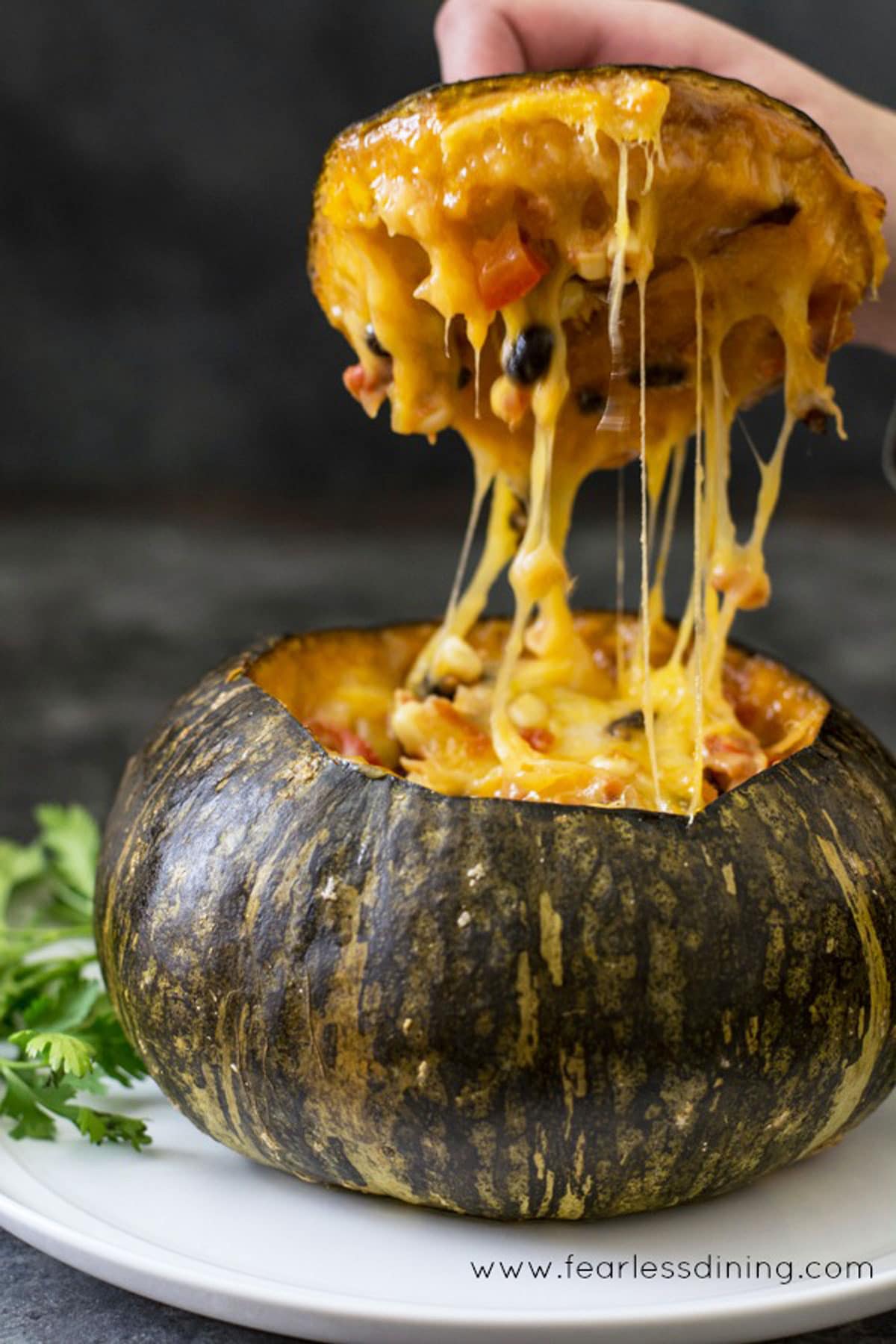 Lifting the top off a roasted stuffed kabocha squash.