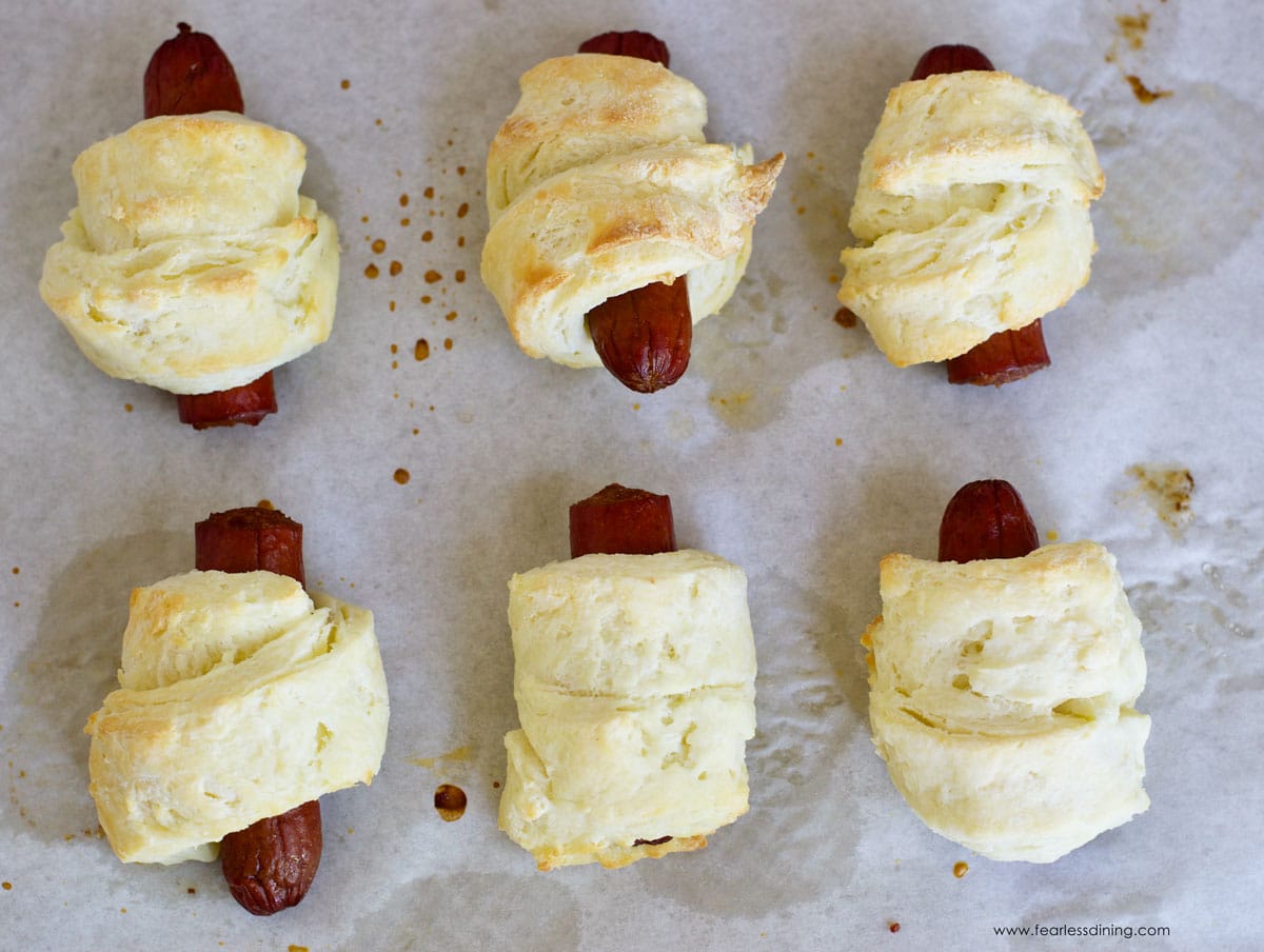 Baked pigs in blankets on a cookie sheet.