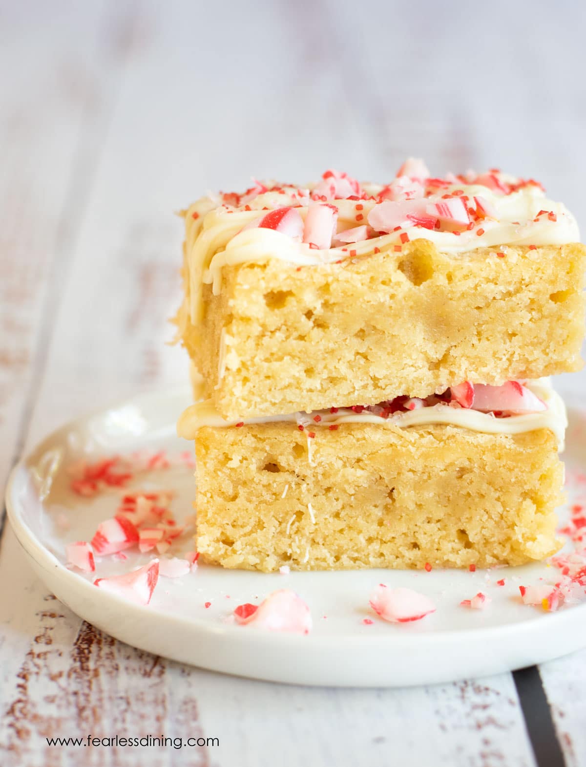 Two peppermint brownies on a white plate.