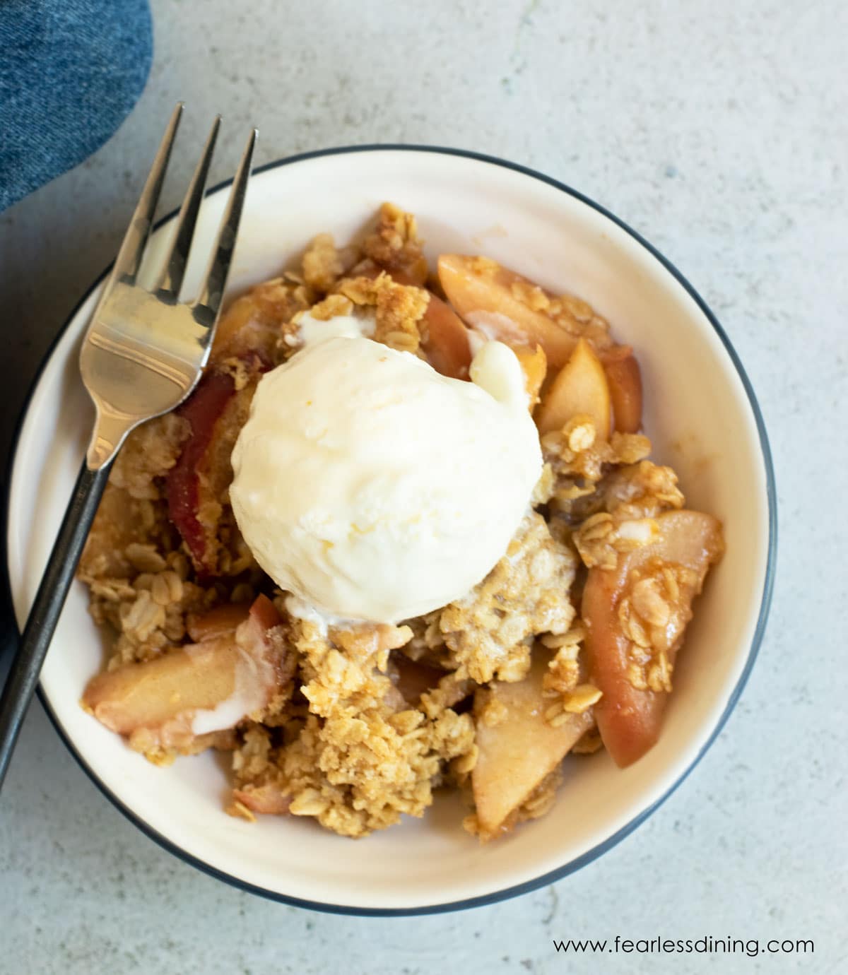 the top view of a bowl of gluten free apple crisp with ice cream