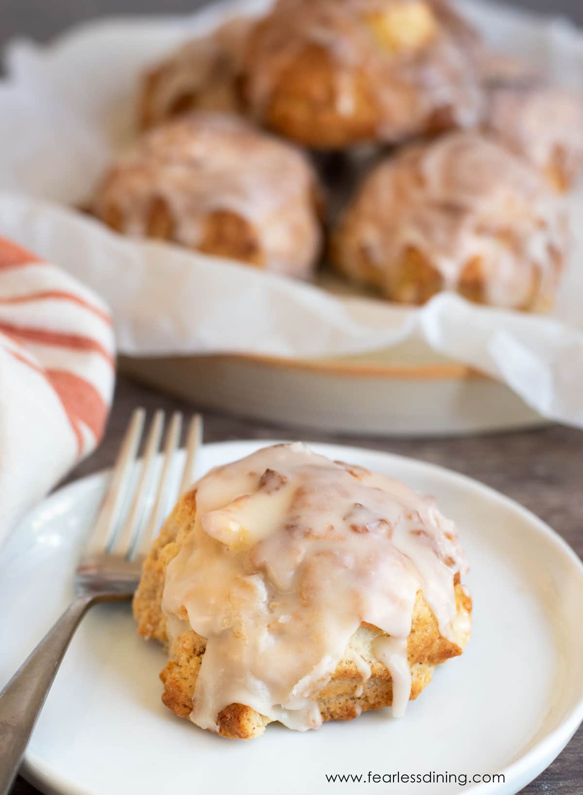 An apple fritter on a white plate.