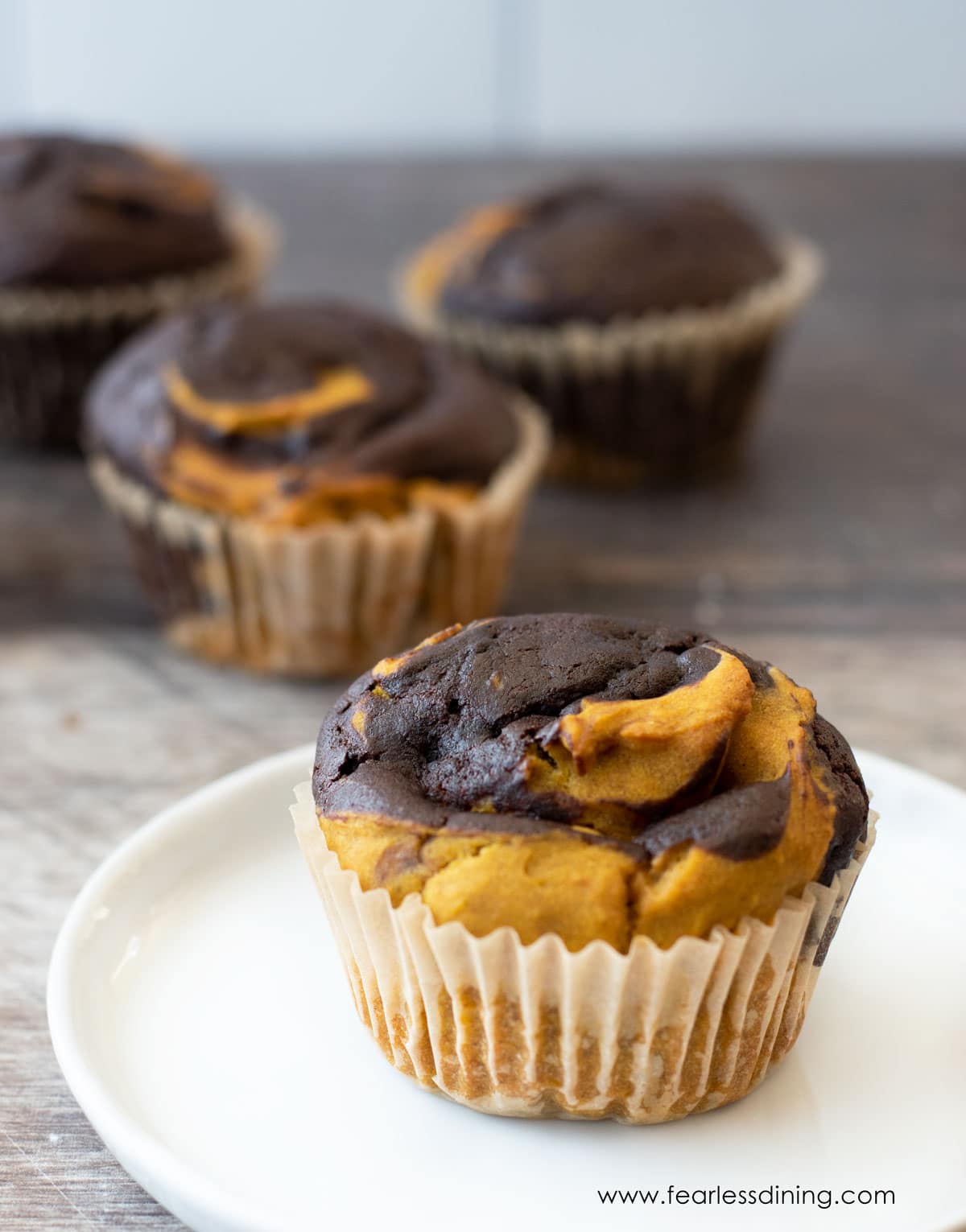 A pumpkin chocolate swirl muffin on a plate.