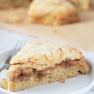 A gluten free cinnamon apple scone on a white plate.