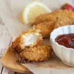 A crispy gluten free fish stick cut in half.
