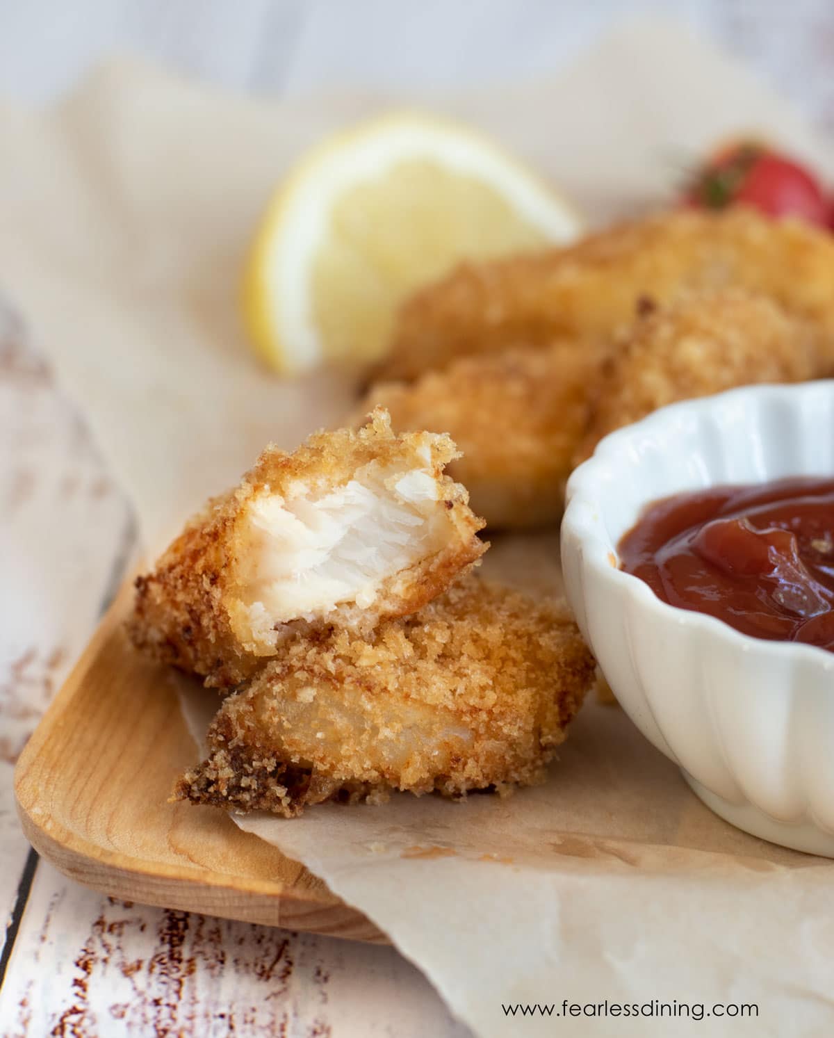 A platter of crispy gluten free fish stick cut in half.