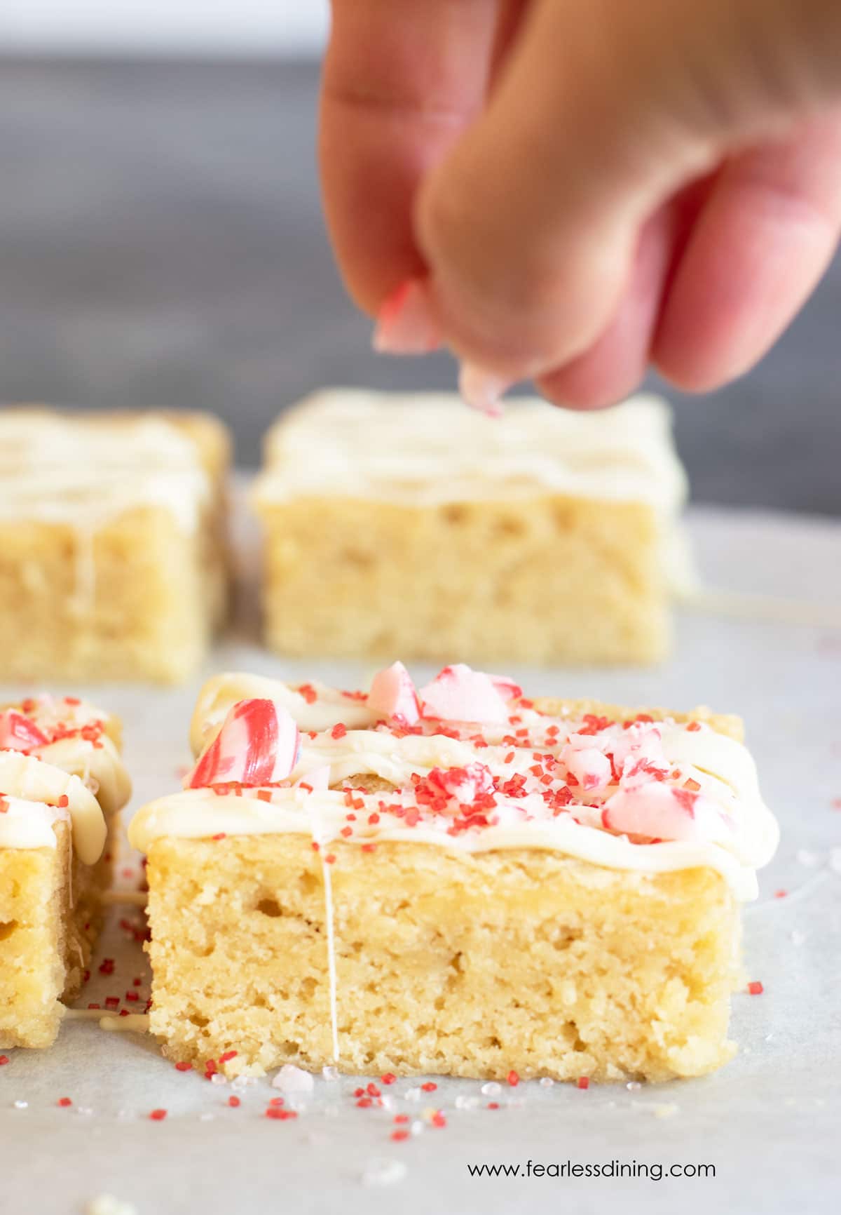 Sprinkling crushed candy cane pieces on peppermint brownies.