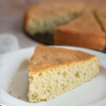 A slice of gluten free sponge cake on a white plate.