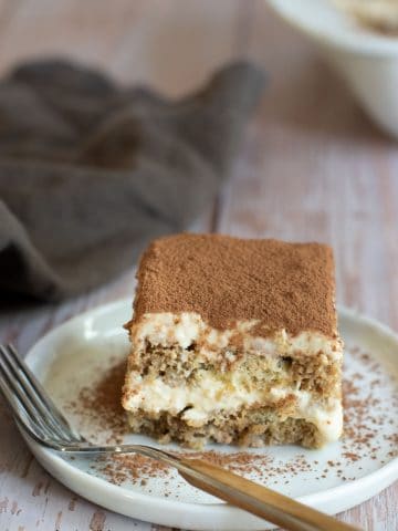 a piece of tiramisu on a plate with a brown fork