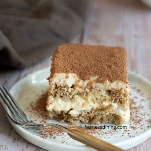A slice of gluten-free tiramisu on a small white plate.