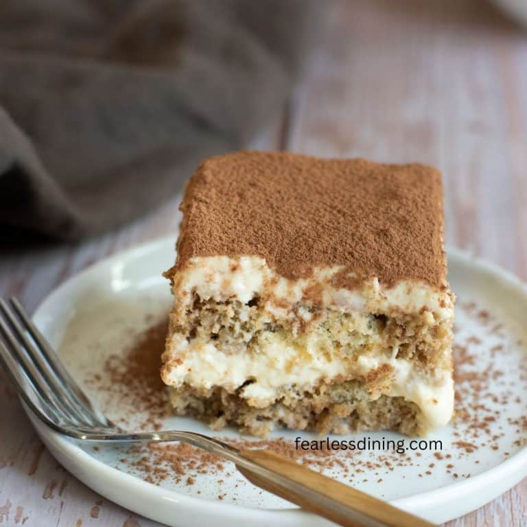 A slice of gluten-free tiramisu on a small white plate.