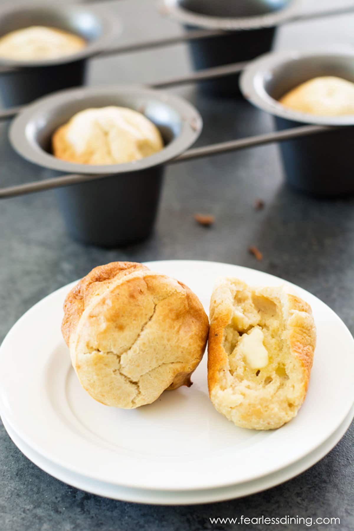 A gluten free pumpkin spice popover cut in half with butter.