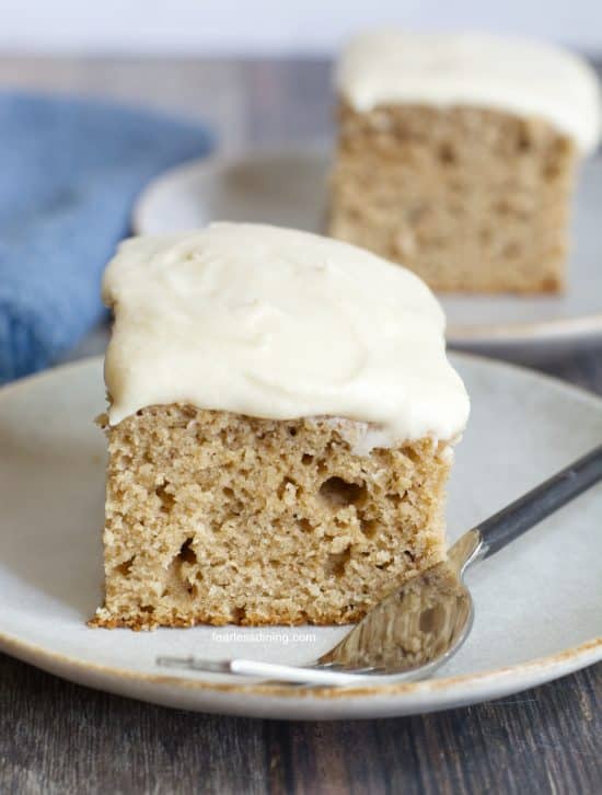 Two slices of gluten-free spice cake topped with vanilla buttercream frosting.