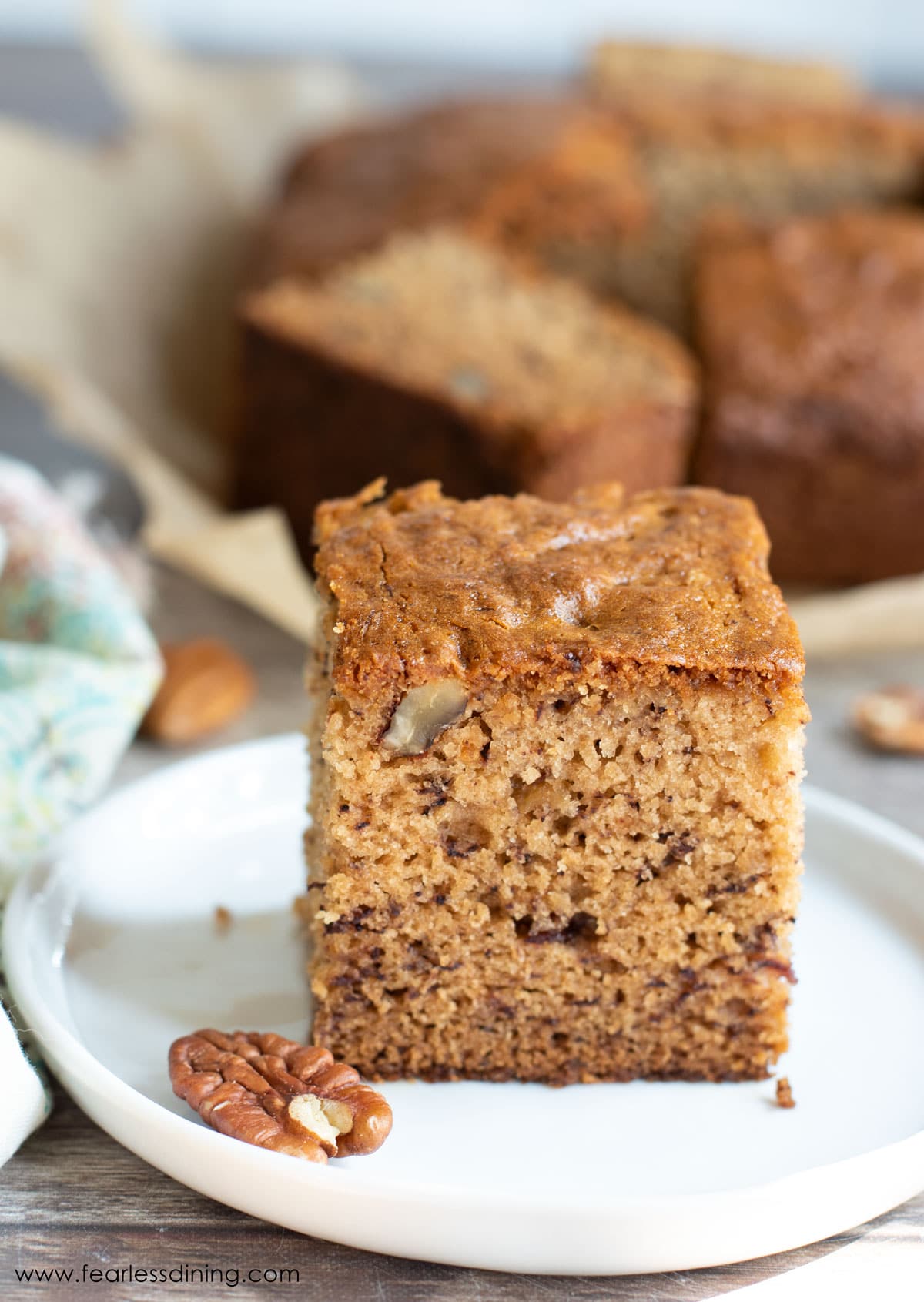 A slice of banana cake on a small white plate.