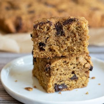 A stack of two gluten free pumpkin cake bars on a plate.