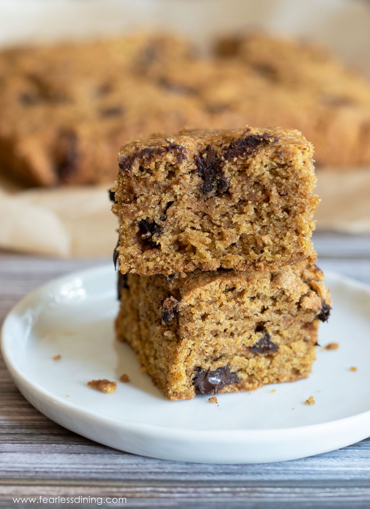 A stack of two gluten free pumpkin cake bars on a plate.