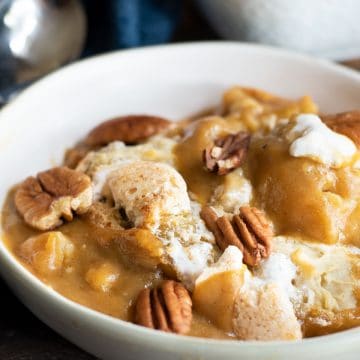 a bowl of gluten free pumpkin cobbler topped with pecans