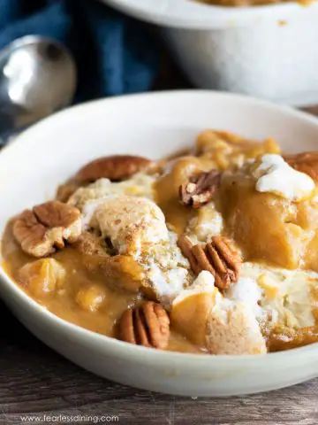 a bowl of gluten free pumpkin cobbler topped with pecans