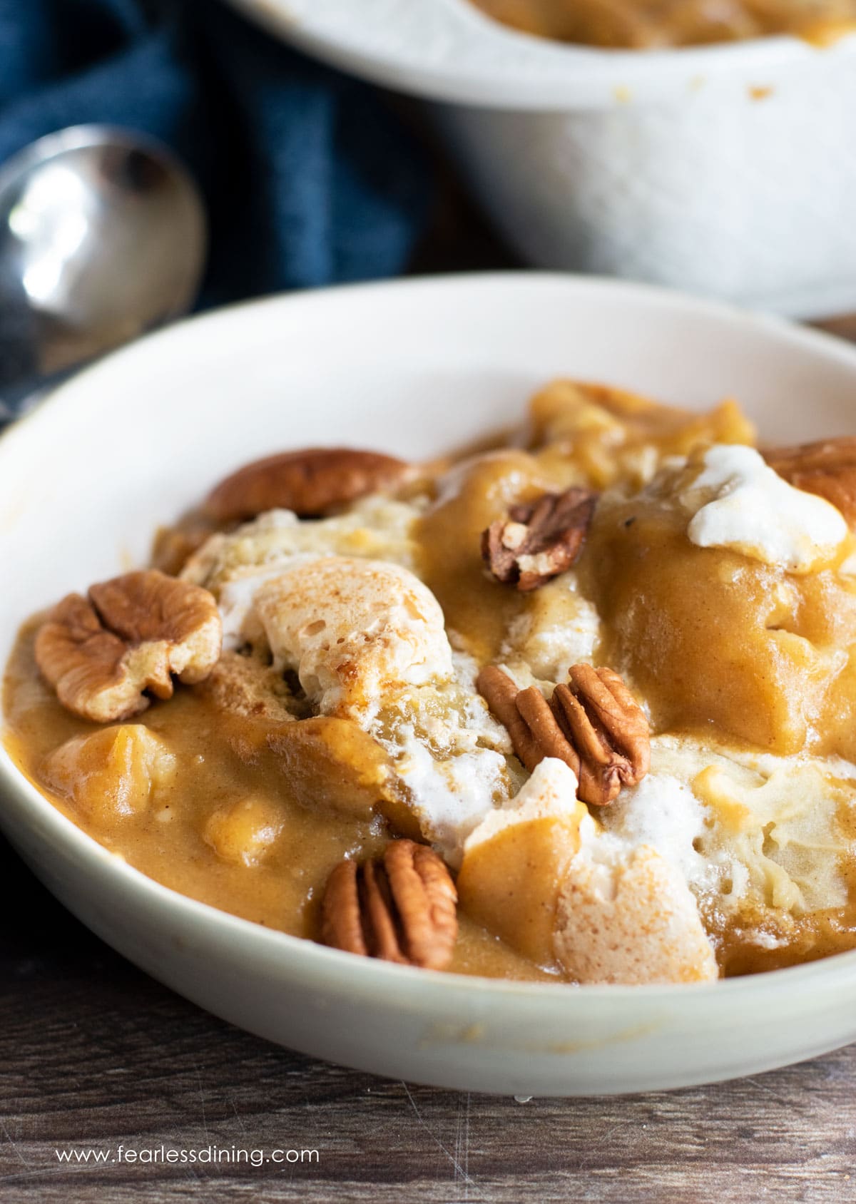 A bowl of gluten free pumpkin cobbler topped with pecans.