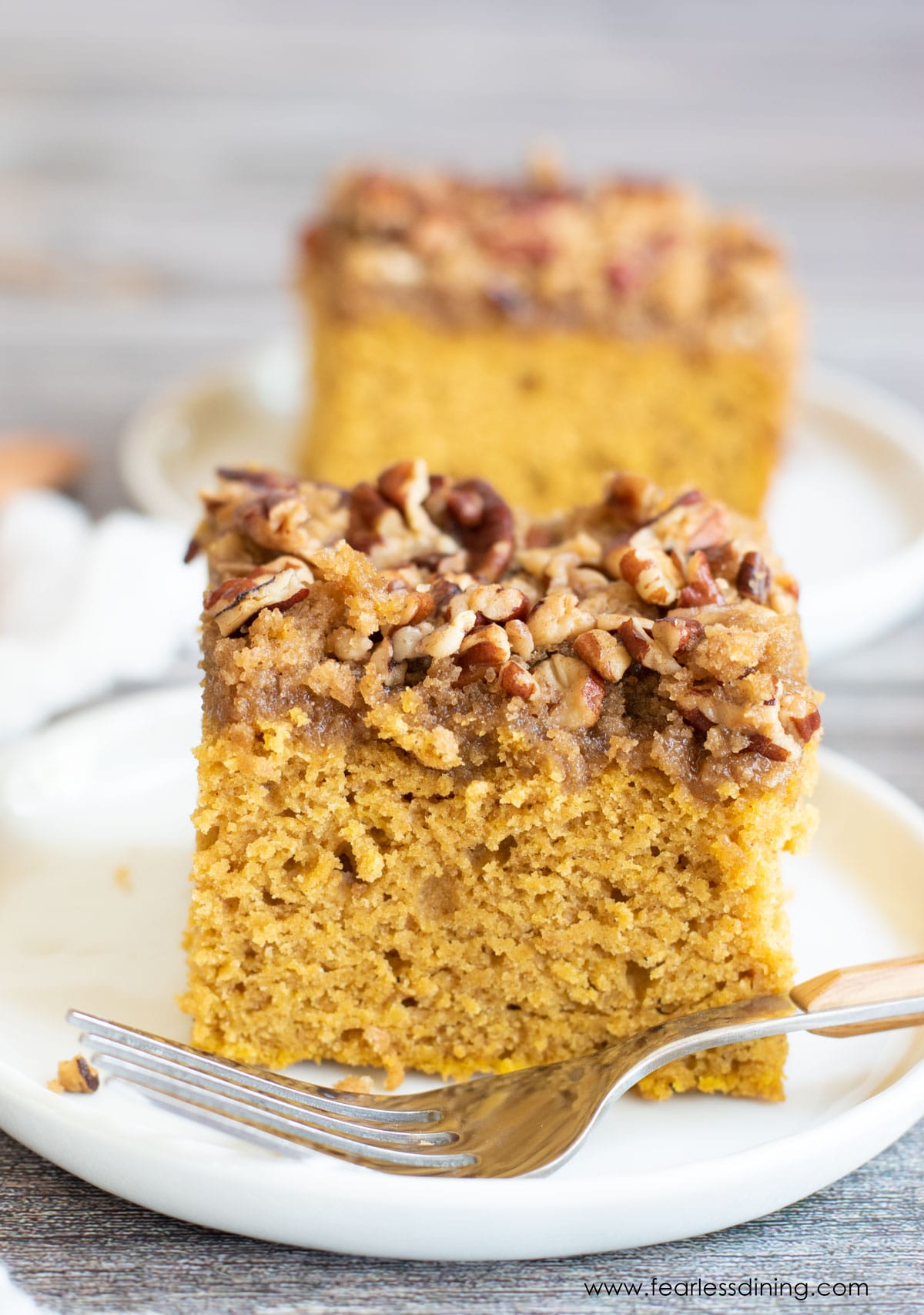 Two slices of gluten free pumpkin coffee cake on white plates.