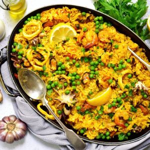 A large serving pan full of paella on a table.
