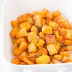 A white baking dish with roasted butternut squash.