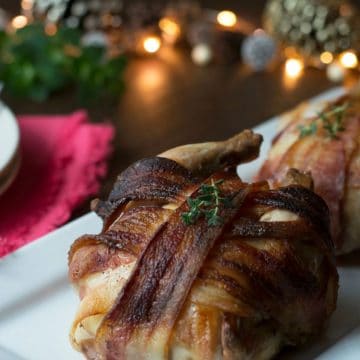 Bacon wrapped cornish hens on a platter.