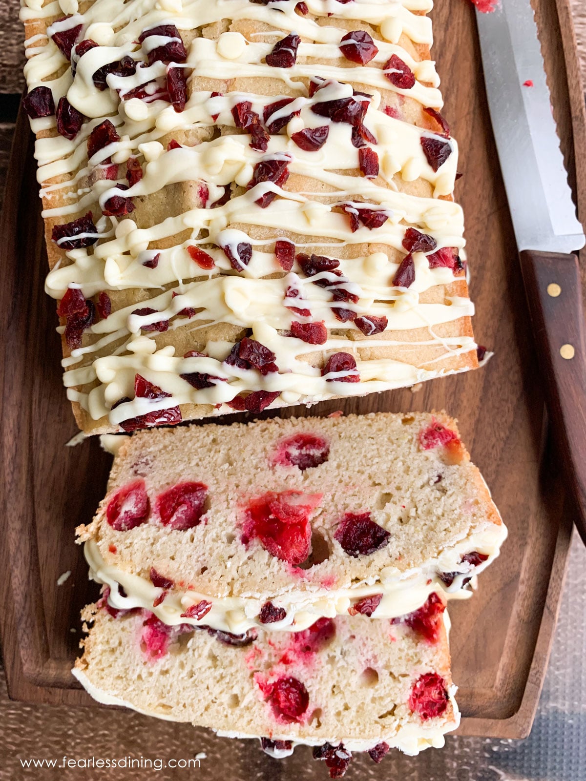 A sliced cranberry pound cake on a cutting board.