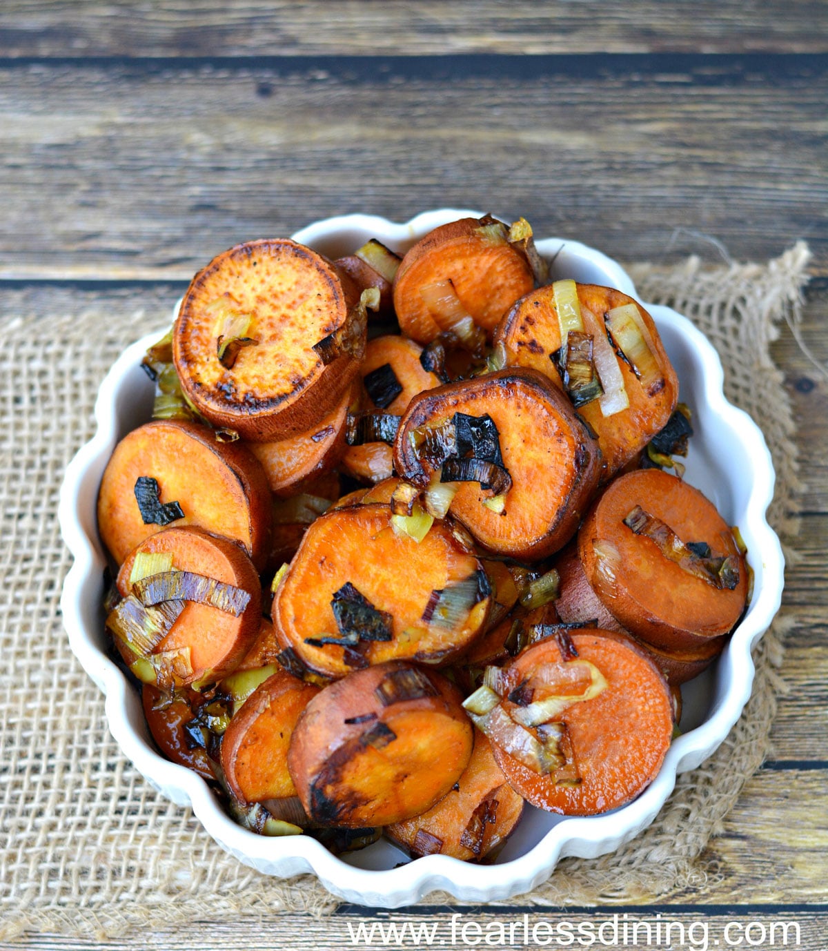 A white bowl filled with pan-fried sweet potato slices.