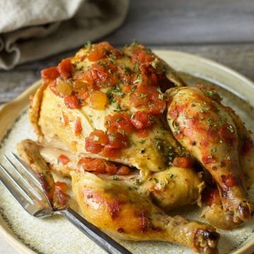 A slow cooker cornish hen on a plate.