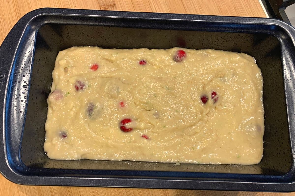 The ranberry cake batter in a loaf pan.