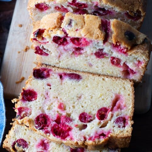 The top view of a sliced loaf of cranberry cake.