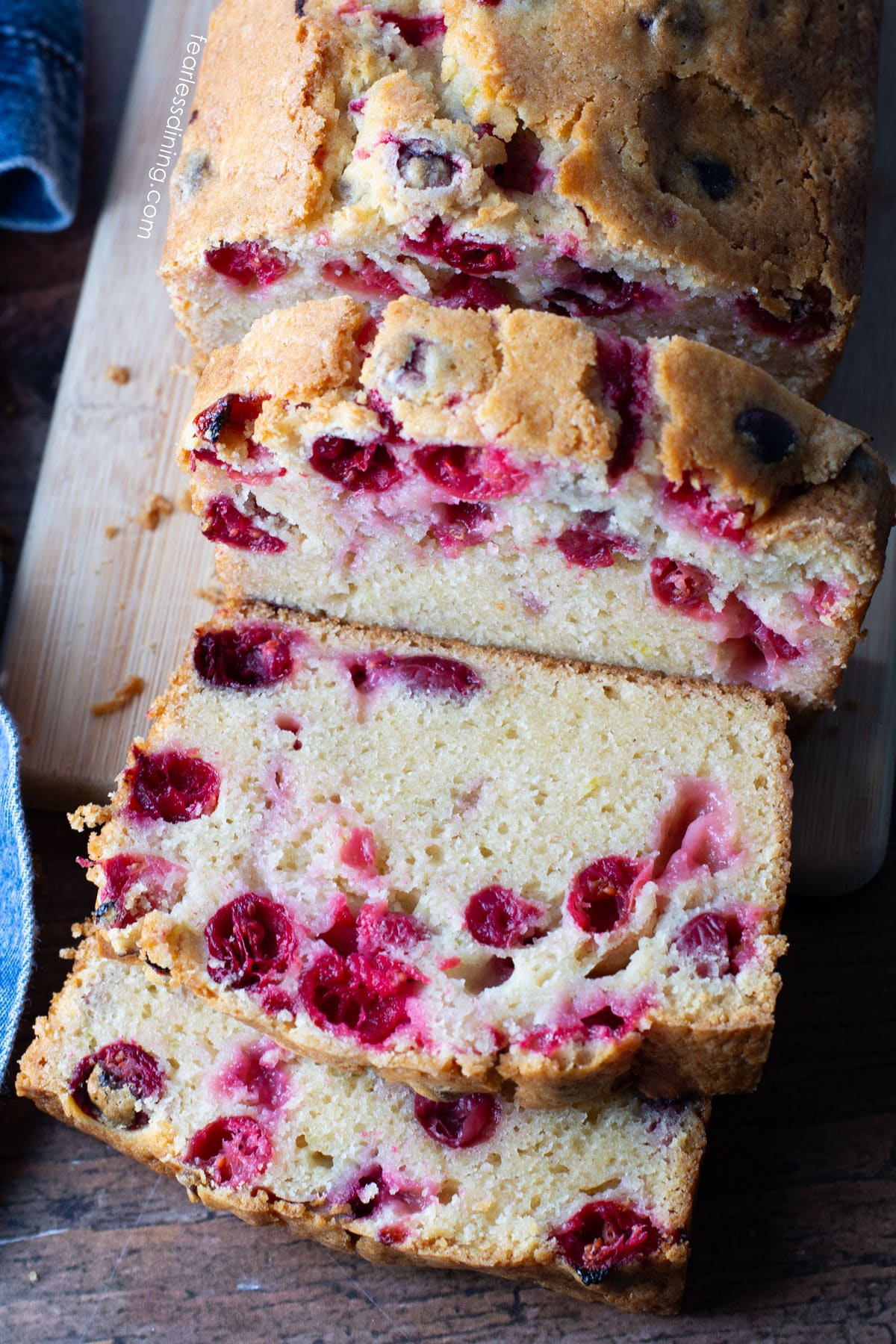 The top view of a sliced loaf of cranberry cake.