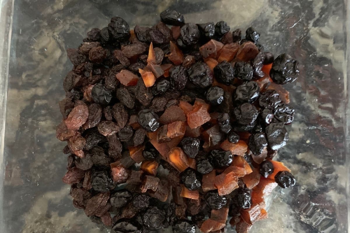 a bowl of dried fruit soaking in rum.