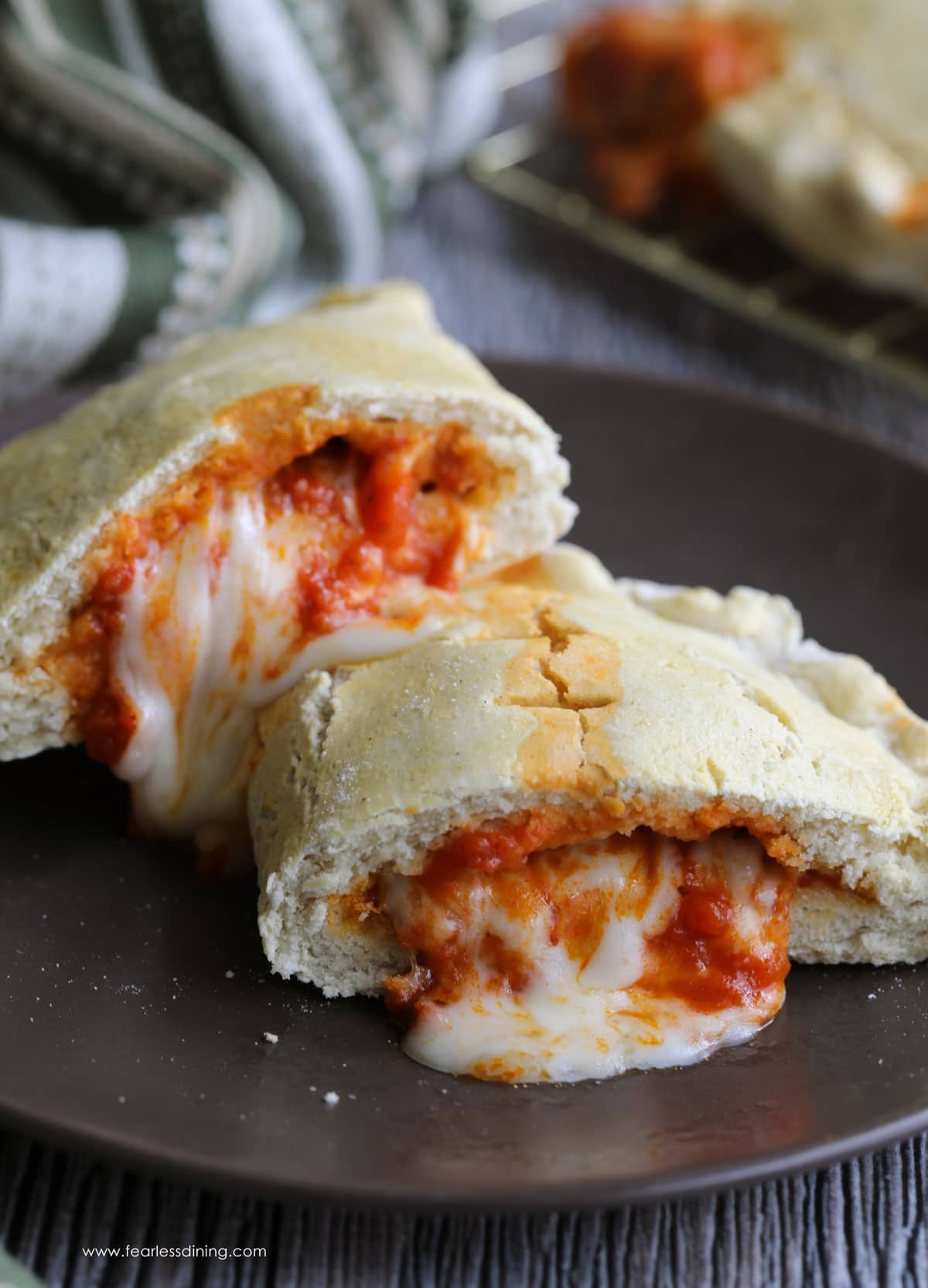 a calzone cut in half tith the cheese and sauce oozing out.