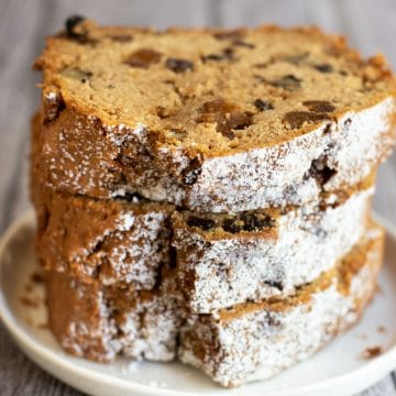 a stack of three slices of gluten free fruit cake on a plate.