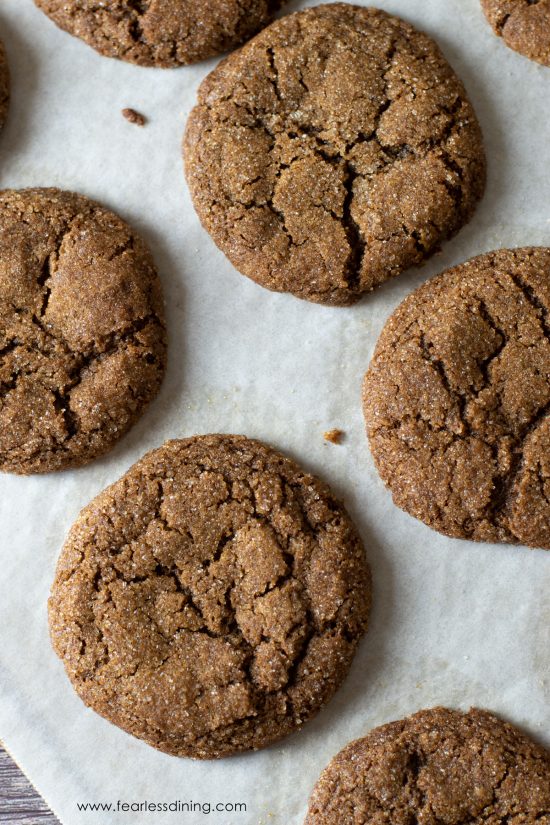 Baked gluten free gingerdoodles on a parchment paper lined cookie sheet.