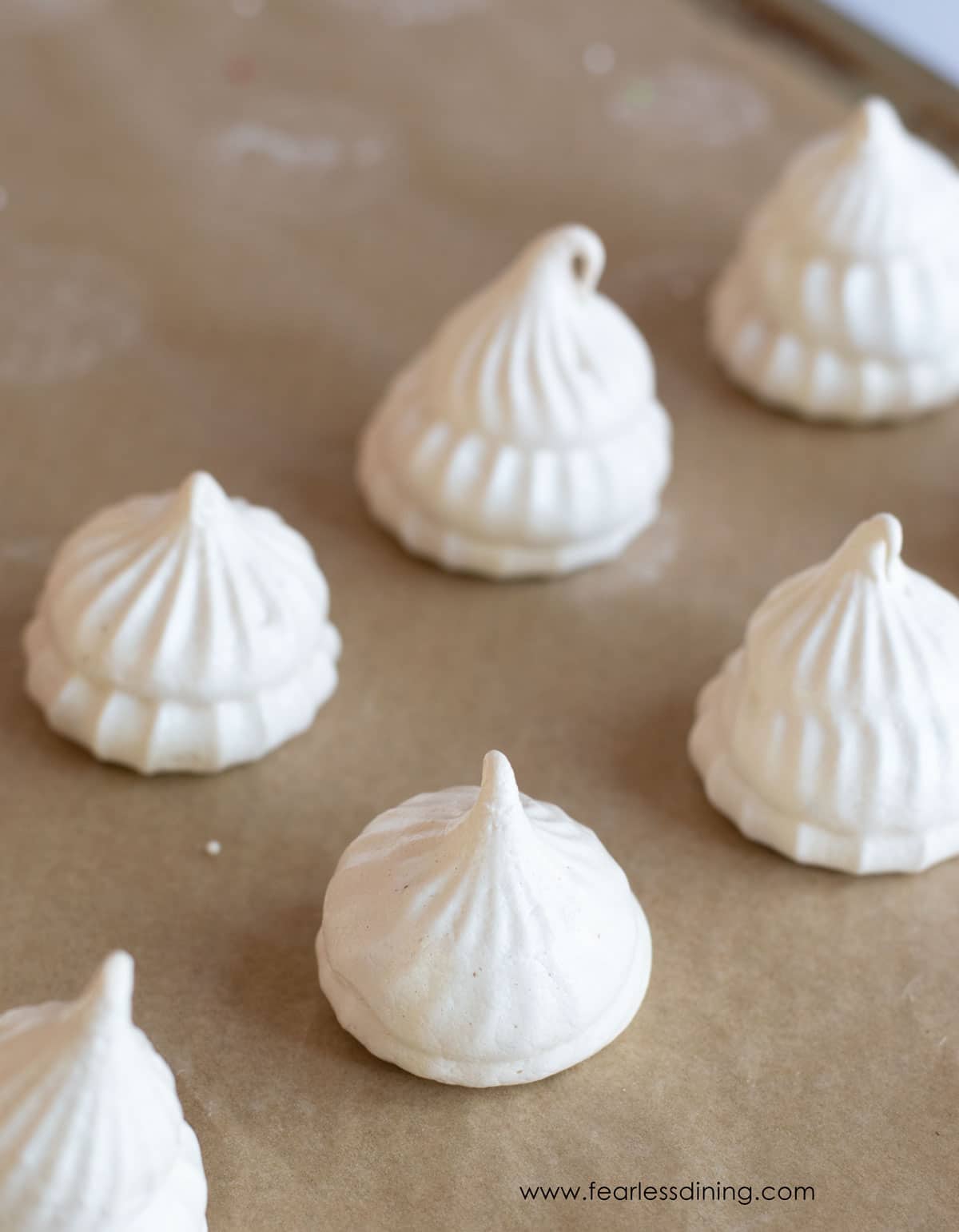 Meringues in rows on a baking sheet.