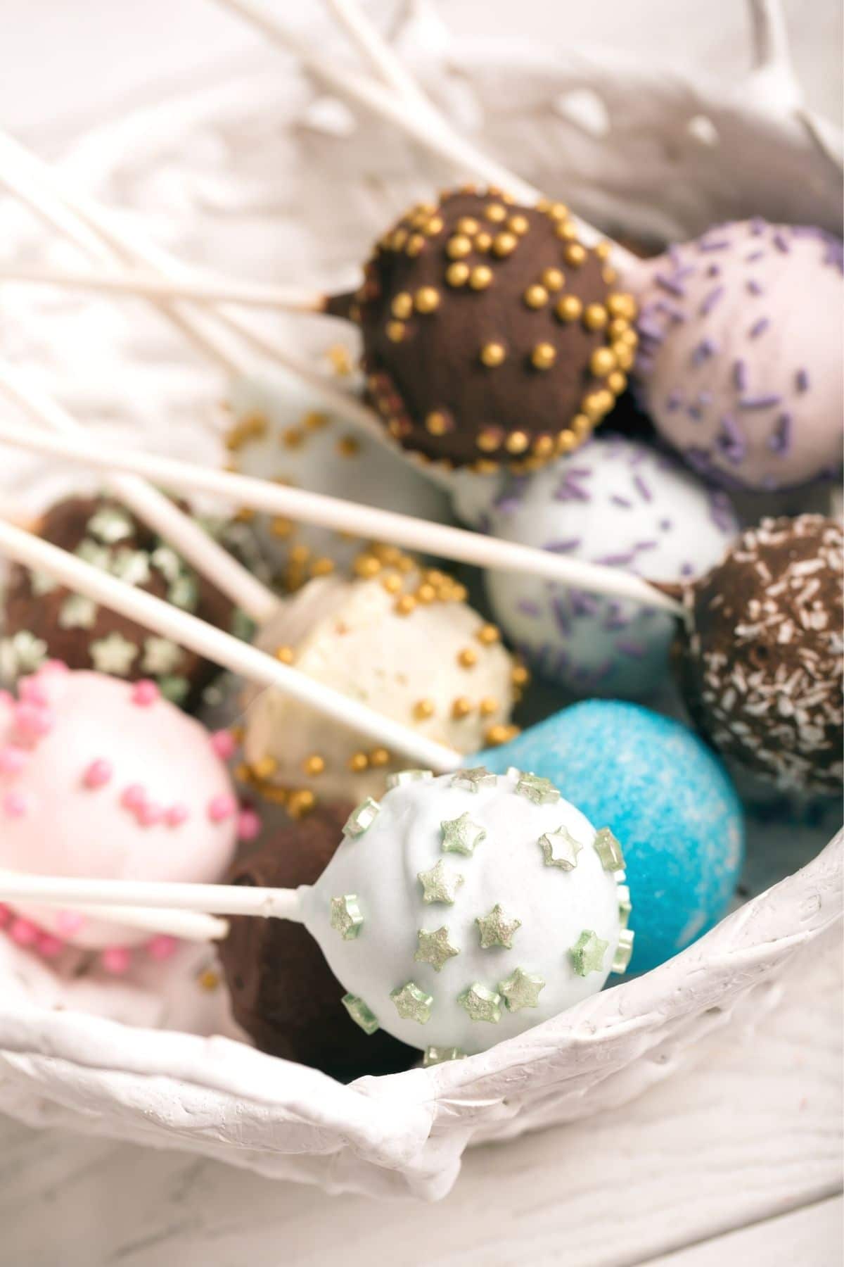 A bunch of cake pops decorated with different sprinkles.
