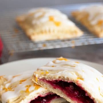 a gluten free cranberry hand pie cut in half on a white plate.