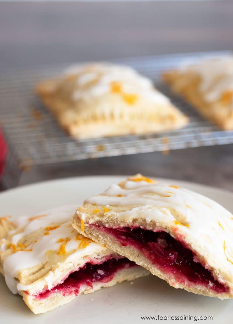 A gluten free cranberry hand pie cut in half on a white plate.