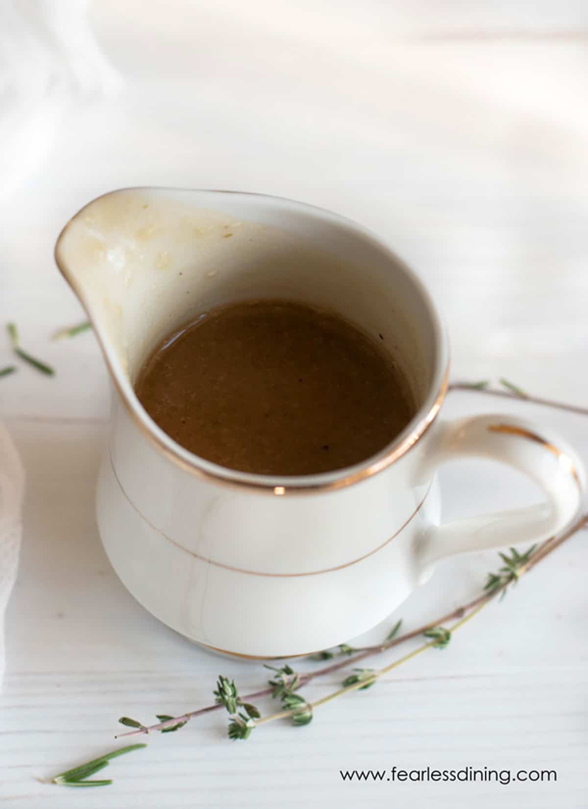 A gravy boat filled with gluten free gravy.