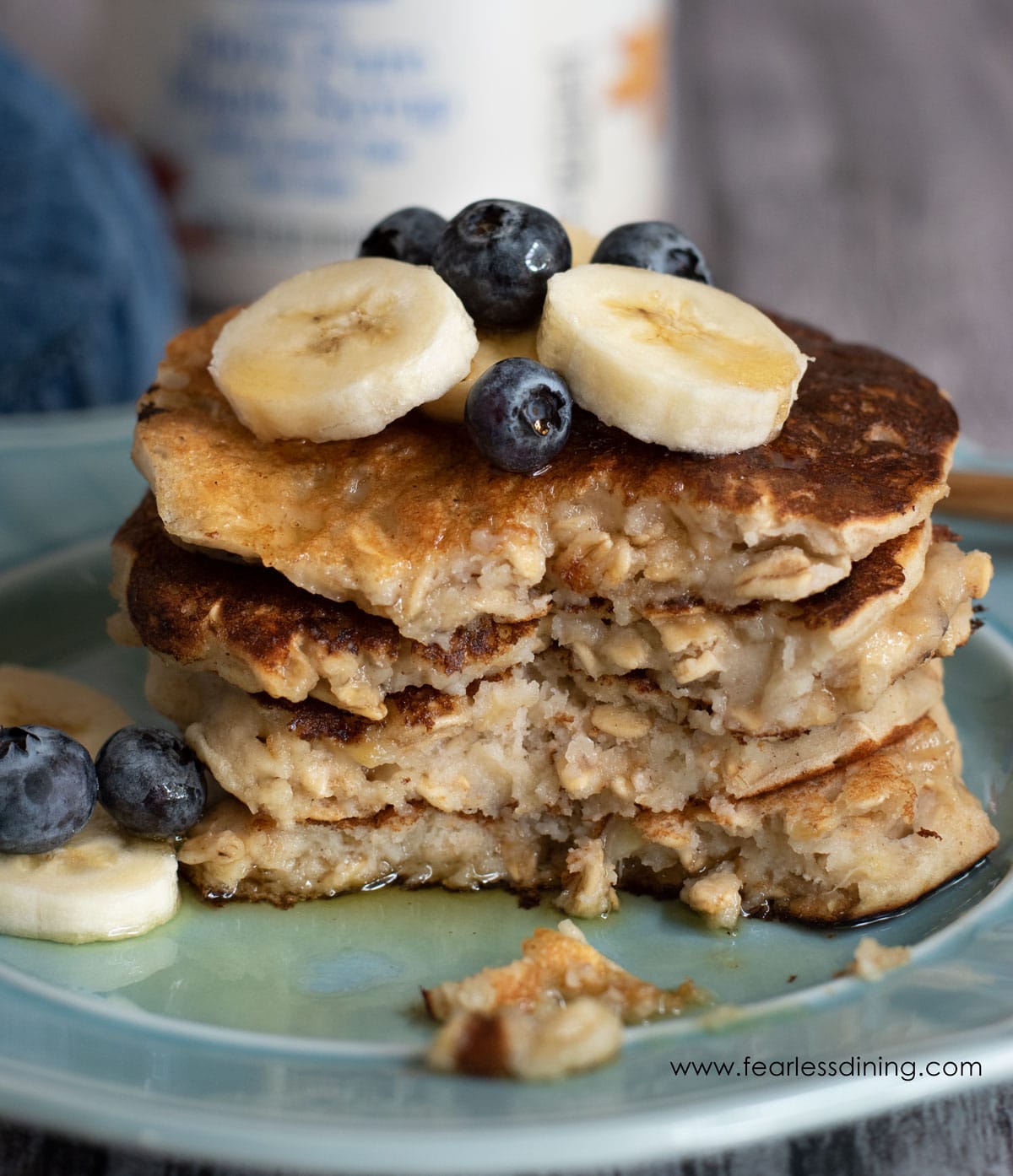 a tall stack of gluten free oatmeal pancakes with a bite cut out