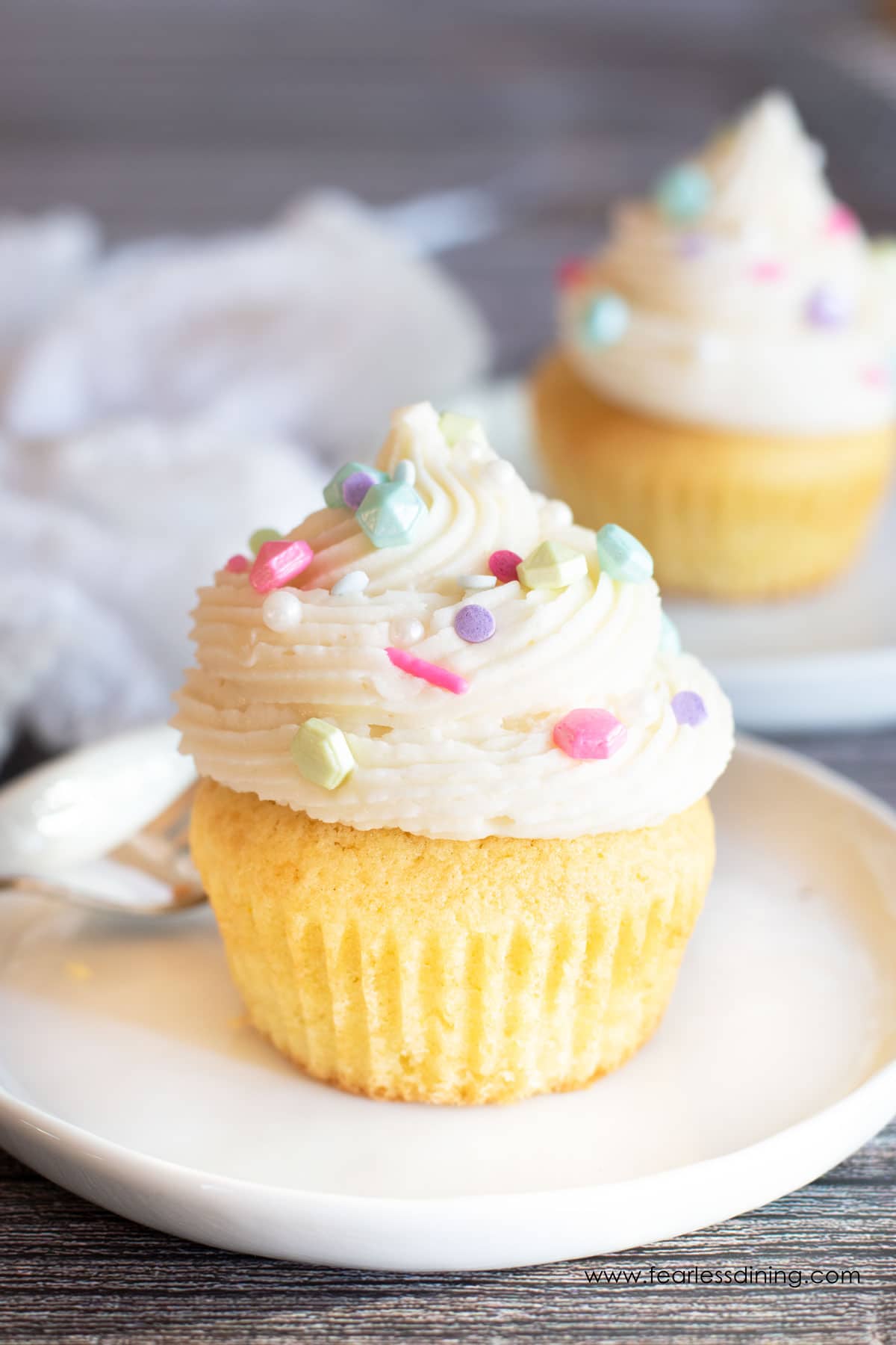 A gluten free frosted cupcakes on a plate.