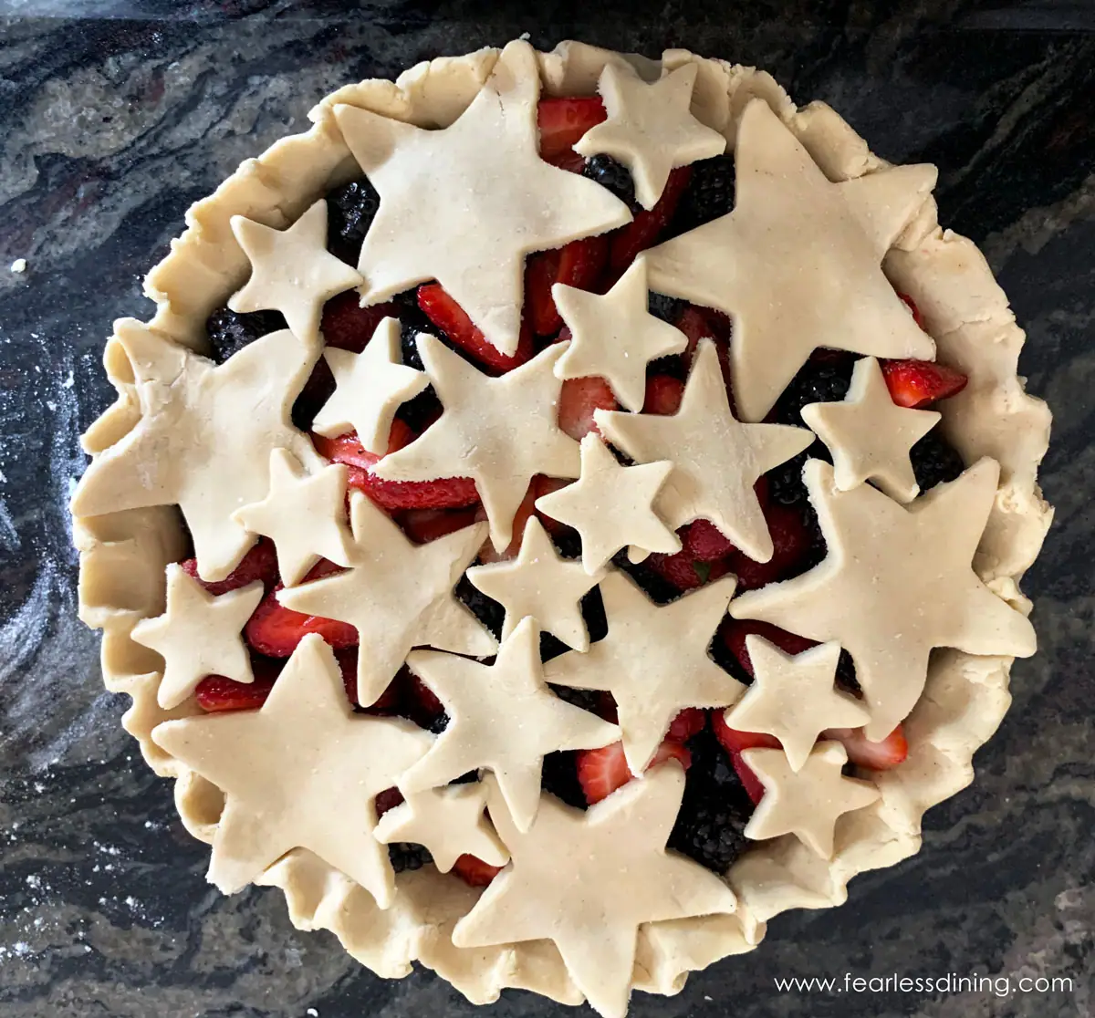 a fruit pie with the top crust made with star cut outs 