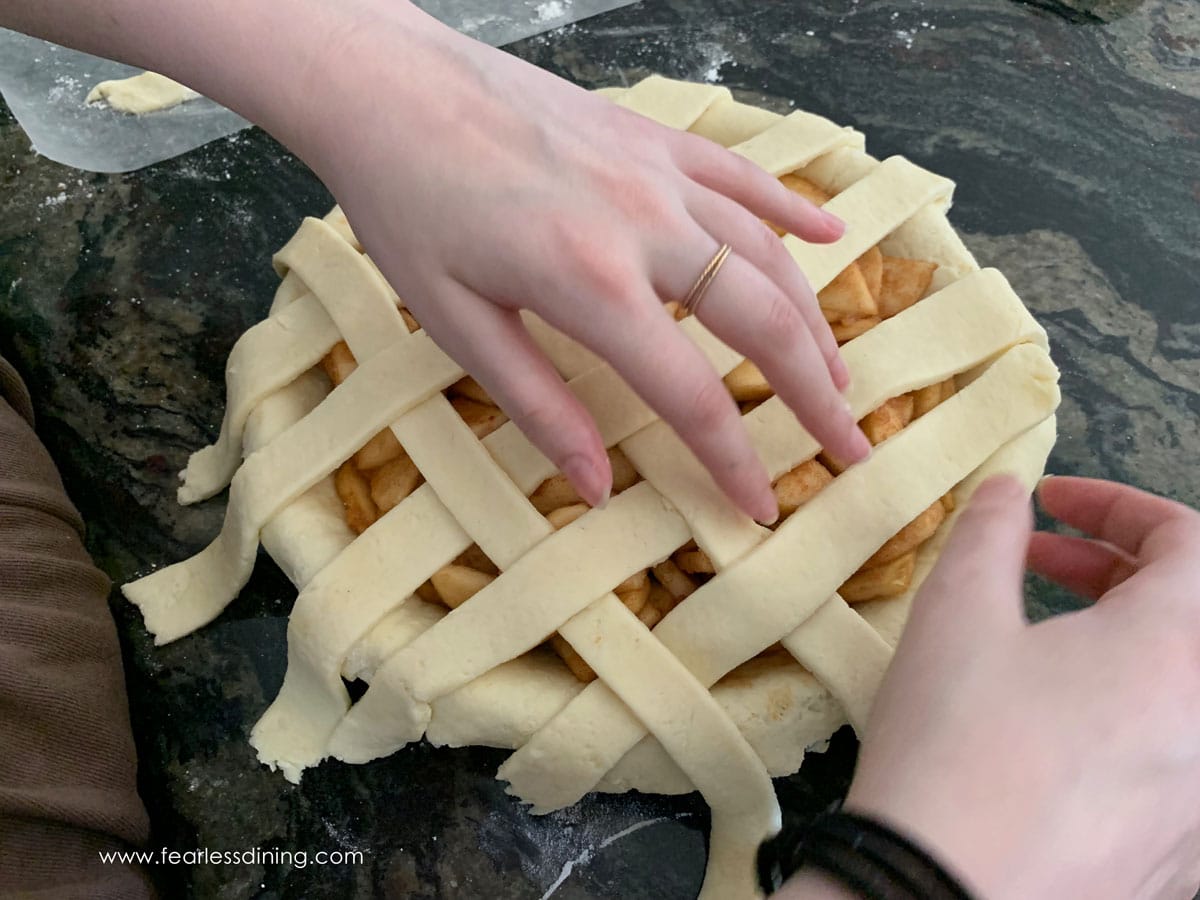 Weaving a lattice crust with pie dough.
