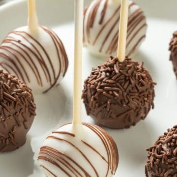 A plate with white chocolate and milk chocolate coated cake pops.