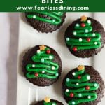 A Pinterest image of brownie bites decorated with Christmas tree icing.