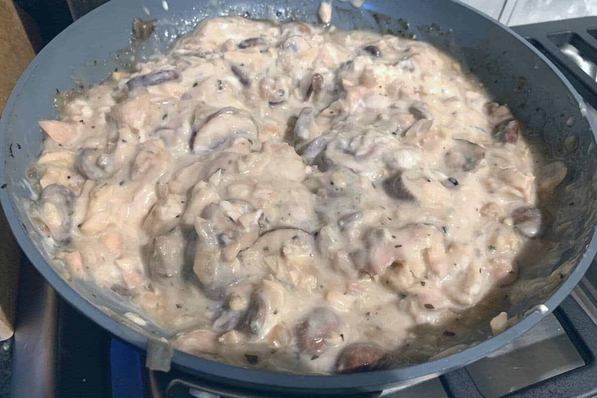 A pan full of cooked tuna casserole vegetables and seasonings.