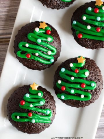 gluten free brownie bites decorated with icing Christmas trees on a platter