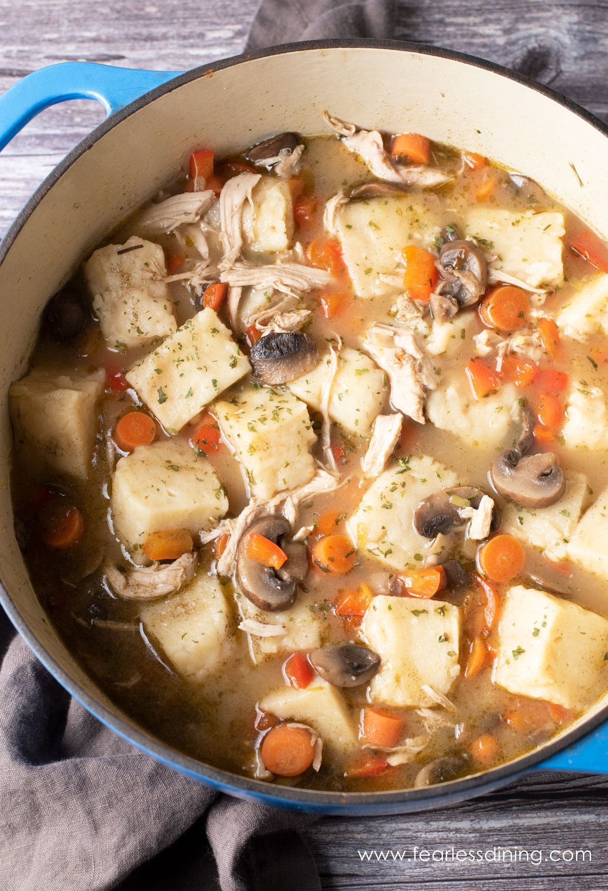 A pot filled with cooked gluten free chicken and dumplings.
